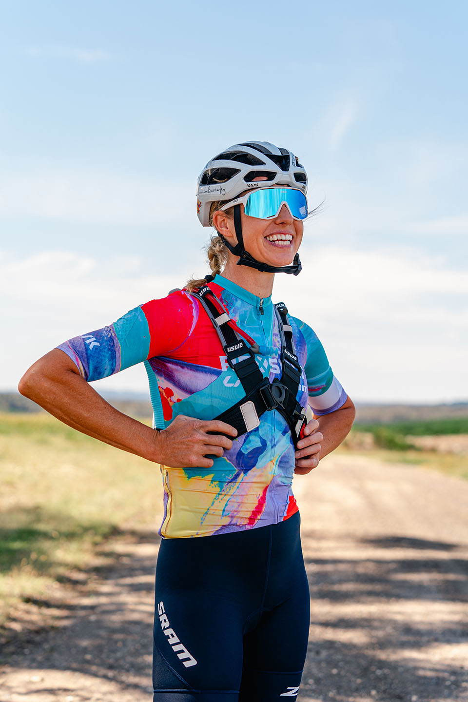Peta Mullens standing on a dirt road, wearing a helmet and sunglasses.